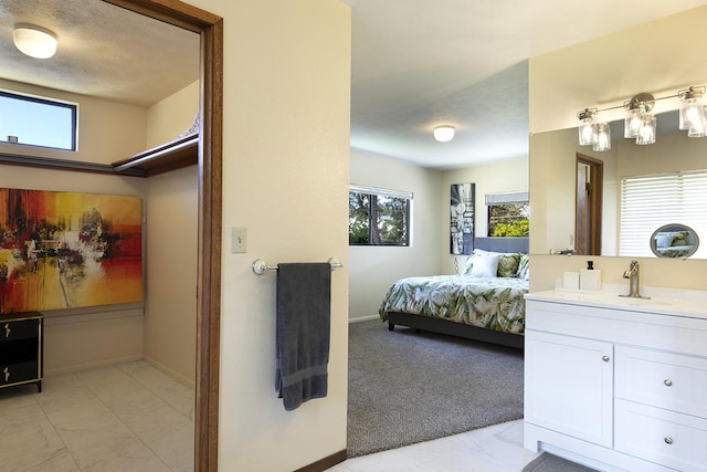 99-7715 Kalehua Pl, Volcano, HI 96778 - bathroom with vanity, marble finish flooring, baseboards, and plenty of natural light