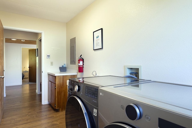 99-7715 Kalehua Pl, Volcano, HI 96778 - washroom with washing machine and clothes dryer, cabinet space, dark wood finished floors, electric panel, and baseboards