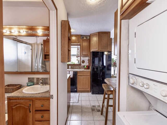 75-6124 Alii Dr Unit 208, Kailua-Kona, HI 96740 - bathroom featuring estacked washer and dryer, vanity, tile patterned floors, and a textured ceiling