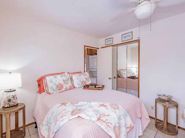 75-6124 Alii Dr Unit 208, Kailua-Kona, HI 96740 - bedroom with estacked washer and dryer, a closet, light tile patterned flooring, and baseboards
