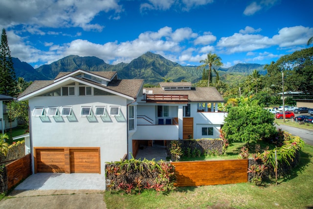 5111 Weke Rd, Hanalei, HI 96714 - view of front of property featuring a garage, a balcony, a mountain view, stucco siding, and driveway