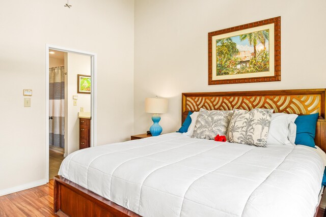 3880 Wyllie Rd Unit 26A, Princeville, HI 96722 - bedroom with wood finished floors, ensuite bathroom, and baseboards