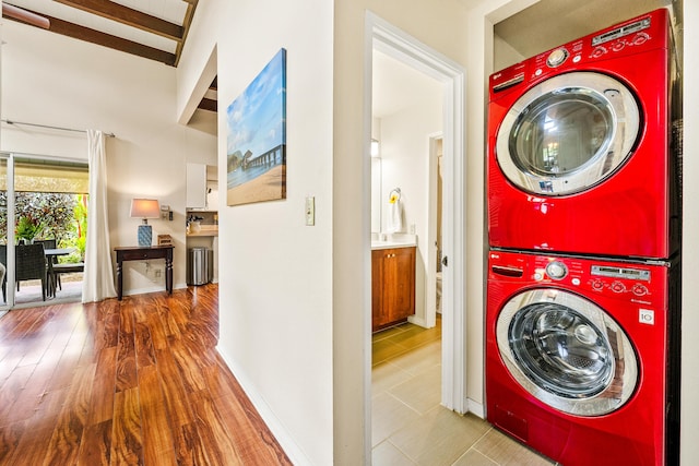 3880 Wyllie Rd Unit 26A, Princeville, HI 96722 - laundry room featuring stacked washer / drying machine, baseboards, and wood finished floors