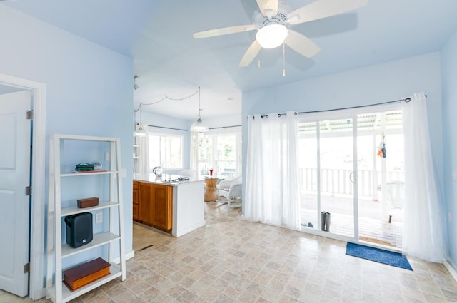 27-624 Kahalii Pl, Pepeekeo, HI 96781 - kitchen featuring brown cabinetry, ceiling fan, hanging light fixtures, and light countertops
