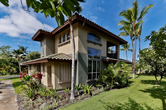 68-1125 Kaniku Dr Unit 706, Kamuela, HI 96743 - view of property exterior featuring stucco siding, a yard, a balcony, and a tiled roof