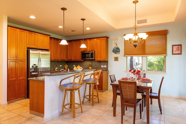 68-1125 Kaniku Dr Unit 706, Kamuela, HI 96743 - kitchen featuring appliances with stainless steel finishes, tasteful backsplash, a chandelier, brown cabinets, and recessed lighting