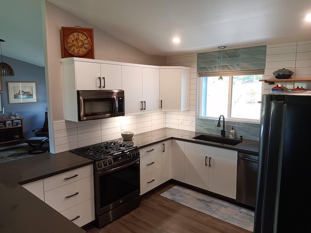 94-1770 Kaulua St, Naalehu, HI 96772 - kitchen featuring appliances with stainless steel finishes, a sink, vaulted ceiling, dark countertops, and dark wood-style flooring