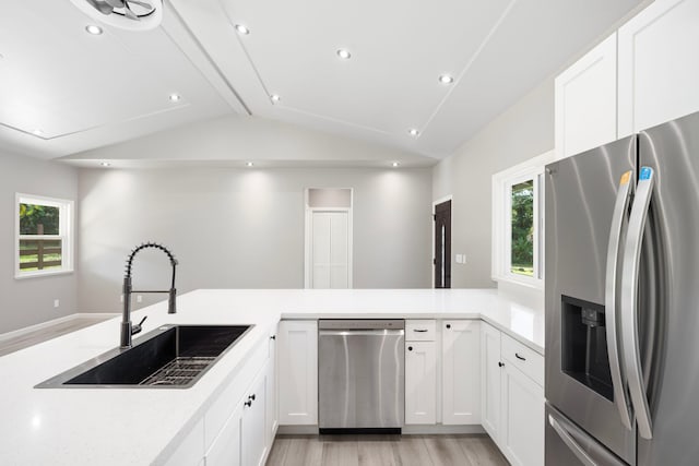 850 Kamalu Rd, Kapaa, HI 96746 - kitchen with stainless steel appliances, a sink, lofted ceiling, light wood-style floors, and white cabinetry