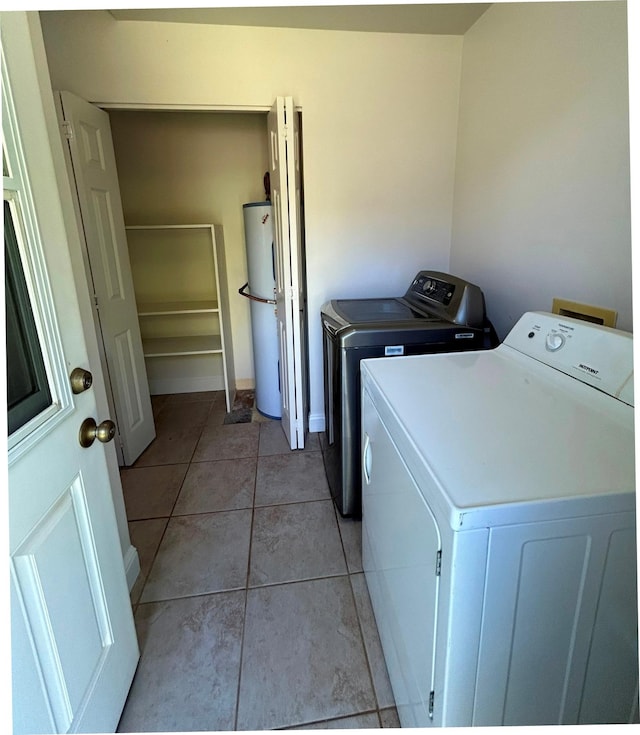 723 Laulea St, Eleele, HI 96705 - washroom with washer and dryer, water heater, light tile patterned flooring, and baseboards