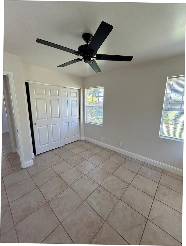 723 Laulea St, Eleele, HI 96705 - unfurnished bedroom featuring light tile patterned floors, a closet, baseboards, and a ceiling fan