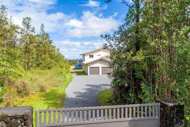 11-3064 Lehua St, Mountain View, HI 96771 - view of front facade with driveway, a garage, and stucco siding
