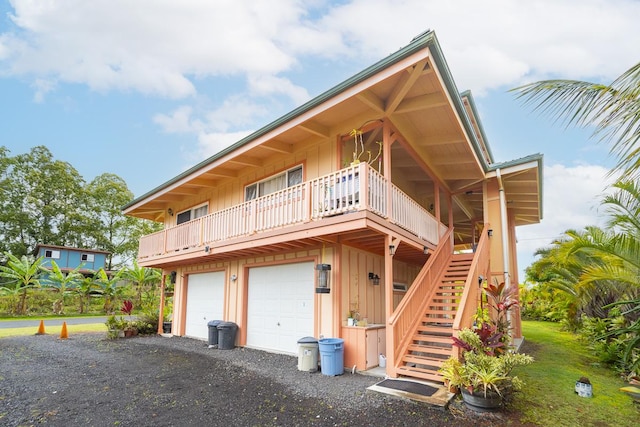 12-7059 Puulena St, Pahoa, HI 96778 - back of house featuring board and batten siding, stairs, an attached garage, and gravel driveway