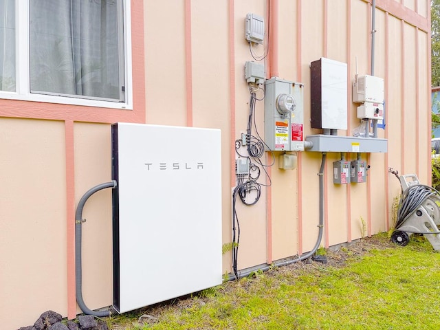 12-7059 Puulena St, Pahoa, HI 96778 - exterior view of wall-mounted power storage, electric meter, related energy utilities, and stucco siding