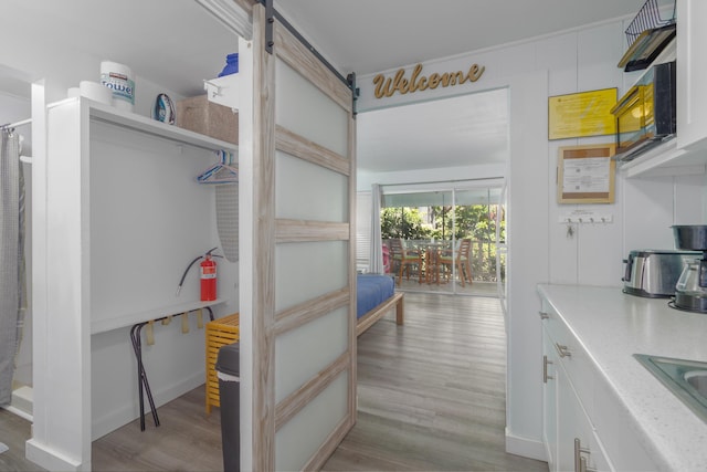 75-5681 Kuakini Hwy Unit S202, Kailua-Kona, HI 96740 - kitchen with wood finished floors, a barn door, light countertops, and a sink