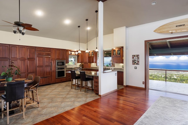 74-1026 Lawaia Rd, Holualoa, HI 96725 - kitchen with stainless steel appliances, a ceiling fan, a center island, high vaulted ceiling, and a breakfast bar
