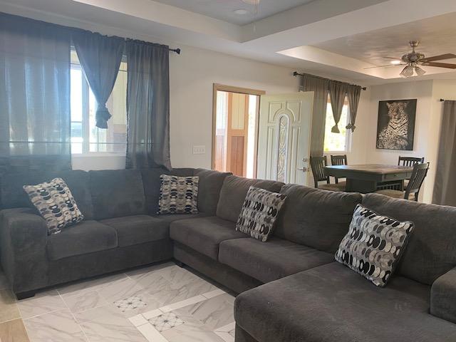 15-1852 33rd Ave, Keaau, HI 96749 - living room featuring ceiling fan, a raised ceiling, and light marble finish flooring