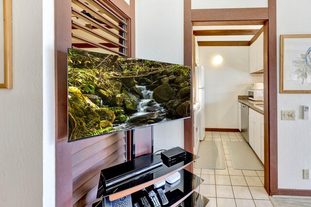 2253 Poipu Rd Unit 138, Koloa, HI 96756 - kitchen with white cabinets, stainless steel dishwasher, light tile patterned flooring, and white microwave
