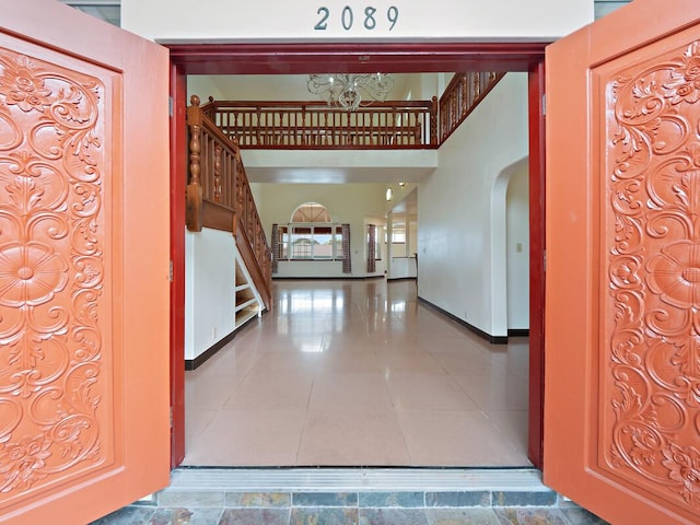 2089 Kinoole St, Hilo, HI 96720 - tiled foyer featuring a chandelier, arched walkways, stairway, and baseboards