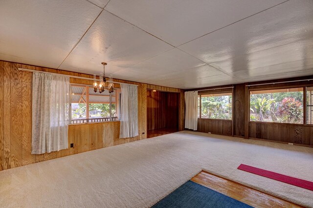 15-2026 33rd Ave, Keaau, HI 96749 - unfurnished room featuring wood walls, a chandelier, and carpet flooring