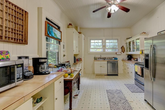 338 Kauila St, Hilo, HI 96720 - kitchen with appliances with stainless steel finishes, light flooring, tile counters, white cabinets, and ceiling fan