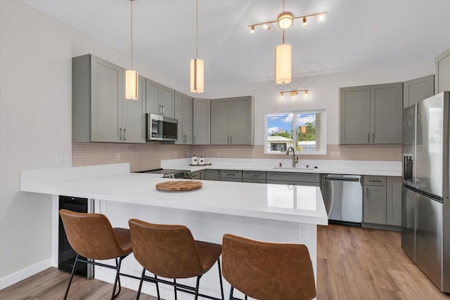 15-1517 Beach Rd, Keaau, HI 96749 - kitchen with appliances with stainless steel finishes, gray cabinetry, a peninsula, tasteful backsplash, and a sink