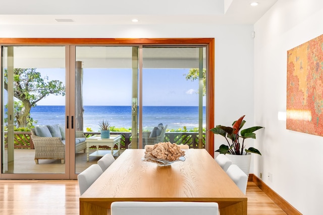 69-1708 Puako Beach Dr, Kamuela, HI 96743 - dining room with light wood-style flooring, healthy amount of natural light, a water view, baseboards, and recessed lighting