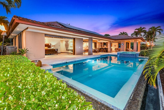 78-7024 Ola Mau St, Kailua-Kona, HI 96740 - pool at dusk with ceiling fan, a patio, a pool with connected hot tub, and an outdoor hangout area