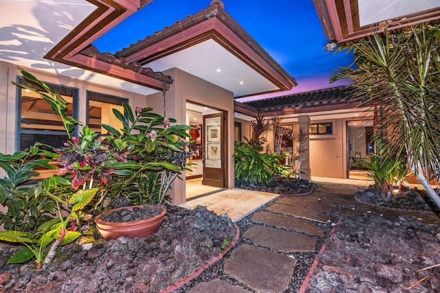 78-7024 Ola Mau St, Kailua-Kona, HI 96740 - view of exterior entry featuring a tiled roof and stucco siding