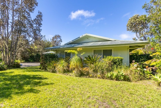 99-1775 Pukeawe Cir, Volcano, HI 96785 - view of side of home with a yard and metal roof