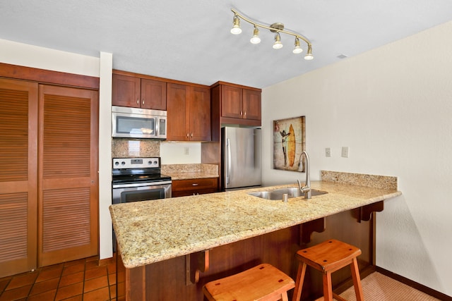 1870 Hoone Rd Unit 803, Koloa, HI 96756 - kitchen featuring stainless steel appliances, a sink, a peninsula, a kitchen breakfast bar, and decorative backsplash