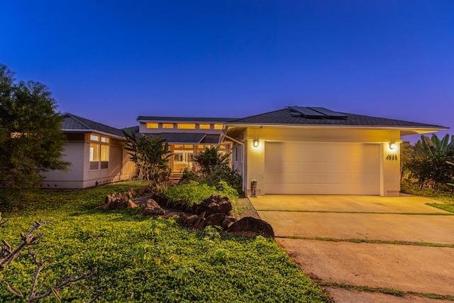 4633 Waiakalua St, Kilauea, HI 96754 - prairie-style home with an attached garage, driveway, roof mounted solar panels, and stucco siding