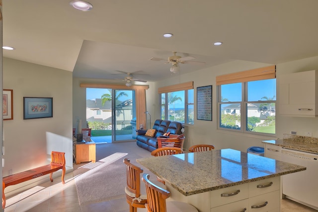 78-6833 Alii Dr Unit E5, Kailua-Kona, HI 96740 - kitchen featuring white dishwasher, white cabinets, a kitchen breakfast bar, a kitchen island, and light tile patterned flooring