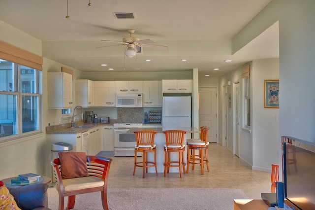 78-6833 Alii Dr Unit E5, Kailua-Kona, HI 96740 - kitchen featuring white appliances, a sink, white cabinetry, a kitchen bar, and recessed lighting