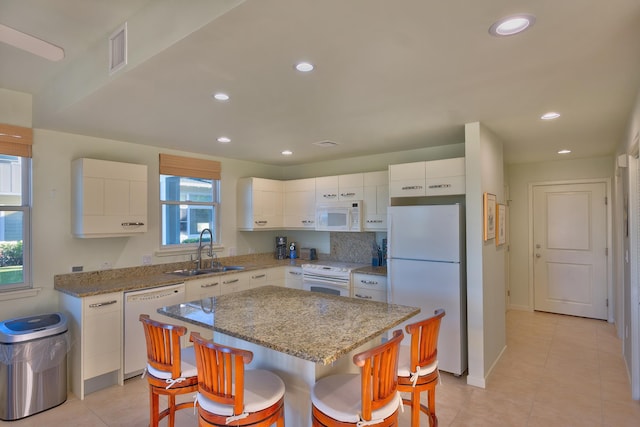 78-6833 Alii Dr Unit E5, Kailua-Kona, HI 96740 - kitchen featuring white appliances, a sink, a breakfast bar, white cabinetry, and light tile patterned flooring
