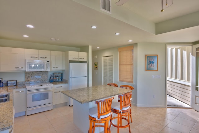 78-6833 Alii Dr Unit E5, Kailua-Kona, HI 96740 - kitchen with white appliances, recessed lighting, a kitchen bar, light tile patterned floors, and decorative backsplash