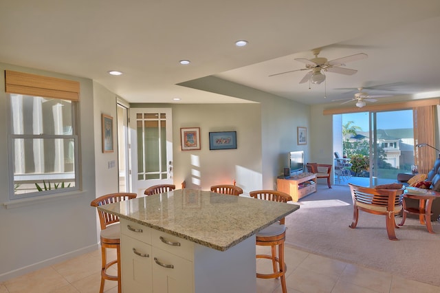78-6833 Alii Dr Unit E5, Kailua-Kona, HI 96740 - kitchen with a kitchen breakfast bar, light tile patterned flooring, white cabinetry, baseboards, and light stone countertops