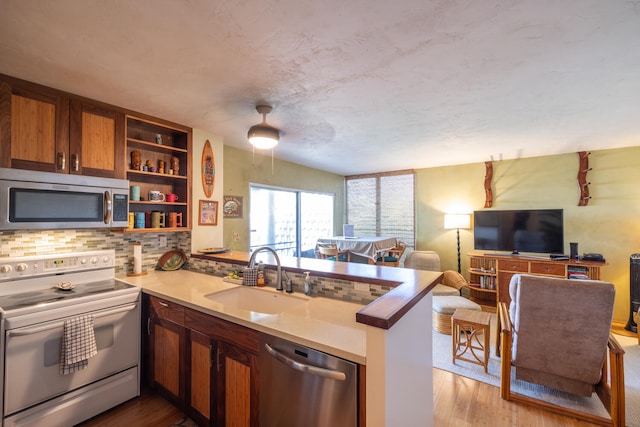 75-6016 Alii Dr Unit 211, Kailua-Kona, HI 96740 - kitchen with appliances with stainless steel finishes, a sink, a peninsula, open floor plan, and backsplash