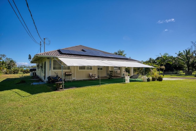 15-1849 14th Ave, Keaau, HI 96749 - back of house with roof mounted solar panels, a metal roof, and a yard