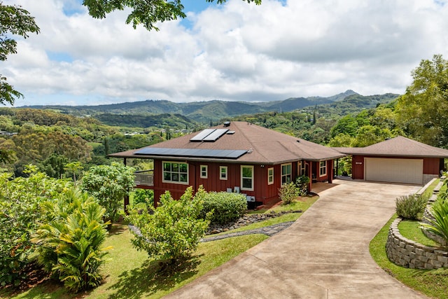 3170 E Iwipoo Rd Unit 2, Kalaheo, HI 96741 - view of front of home featuring concrete driveway, a garage, a mountain view, solar panels, and board and batten siding