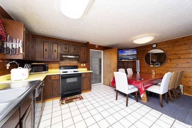 1890 Kaiao St, Hilo, HI 96720 - kitchen featuring electric range oven, stainless steel microwave, under cabinet range hood, dishwasher, and wood walls