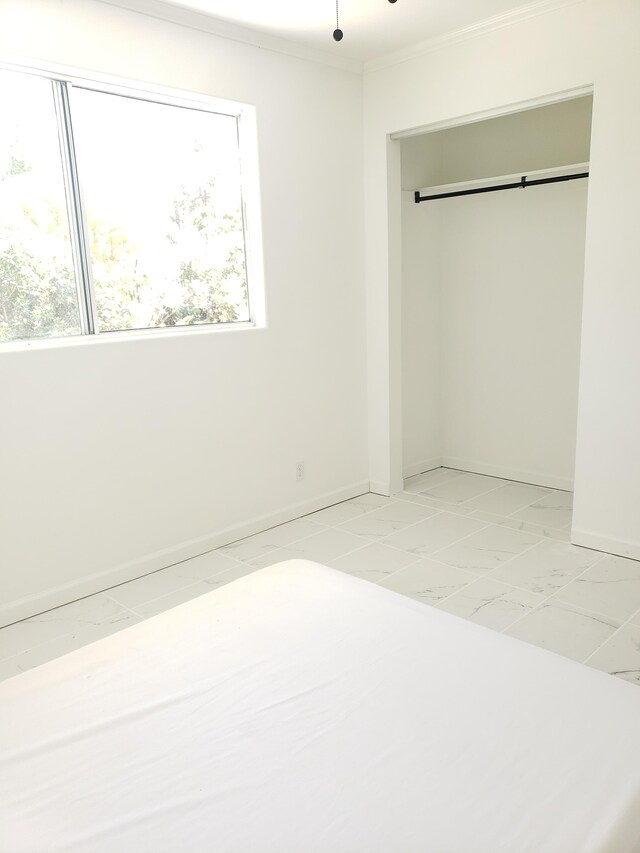 15-1826 32nd Ave, Keaau, HI 96749 - unfurnished bedroom featuring light marble finish flooring, multiple windows, baseboards, crown molding, and a closet
