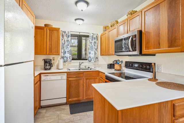 4460 Nehe Rd Unit 116, Lihue, HI 96766 - kitchen featuring white appliances, a sink, light countertops, a peninsula, and a textured ceiling