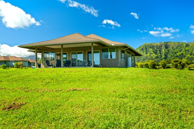 6421-L Hauiki Rd, Kapaa, HI 96746 - back of property with board and batten siding, a mountain view, and a lawn