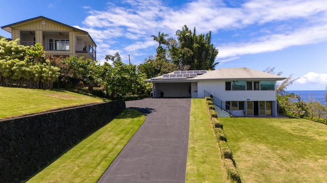 224 Paukaa Dr, Hilo, HI 96720 - view of front of property featuring solar panels, a front lawn, driveway, and a garage
