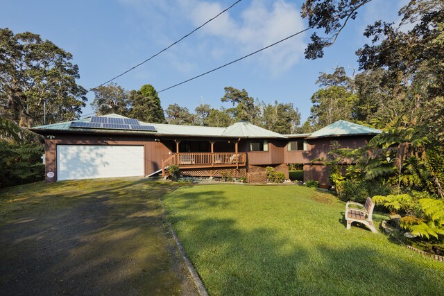 19-4235 Wright Rd, Volcano, HI 96785 - ranch-style house featuring an attached garage, roof mounted solar panels, dirt driveway, and a front lawn