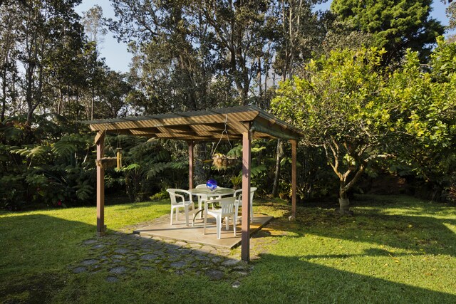 19-4235 Wright Rd, Volcano, HI 96785 - view of green lawn with a patio area, a pergola, and view of wooded area