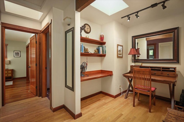 82-6289 Kahauloa St, Captain Cook, HI 96704 - corridor featuring a skylight, light wood finished floors, rail lighting, baseboards, and a desk