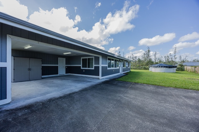 16-2042 Sandalwood Dr, Pahoa, HI 96778 - view of side of home featuring a lawn, concrete driveway, and a carport