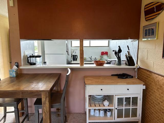 1875 Kalanianaole St Unit 209, Hilo, HI 96720 - kitchen with freestanding refrigerator, white cabinets, and backsplash