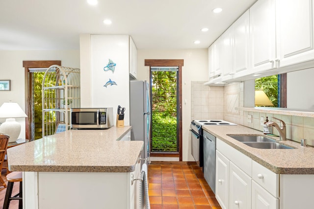 2721 Poipu Rd Unit 100, Koloa, HI 96756 - kitchen with appliances with stainless steel finishes, plenty of natural light, a peninsula, decorative backsplash, and recessed lighting